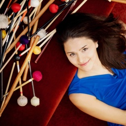 Percussionistin Vivi Vassileva liegt zwischen Sticks und Schlägeln auf dem Boden 