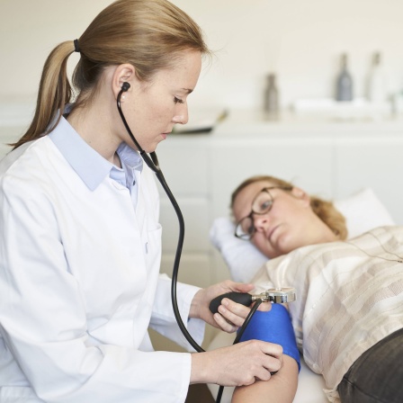 Ärztin misst den Blutdruck einer Patientin