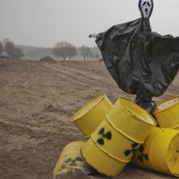 Eine Anti-Atom-Protest-Puppe mit gelben Atommüllfässern auf einem Acker bei einem Castor-Transport nach Gorleben.