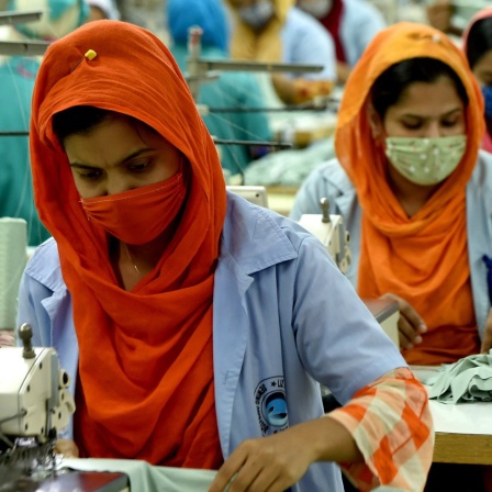 Frauen mit Mund-Nasen-Bedeckungen arbeiten in einer Bekleidungsfabrik in Gazipur, Bangladesch, 03.01.2021