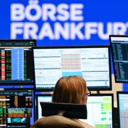 Eine Wertpapierhändlerin von der ICF Bank blickt an ihrem Arbeitsplatz auf dem Parkett der Frankfurter Wertpapierbörse auf ihre Monitore.