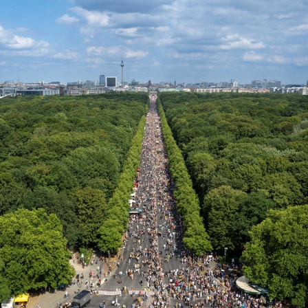 Eine Menschenmenge zieht in Berlin zum Brandenburger Tor