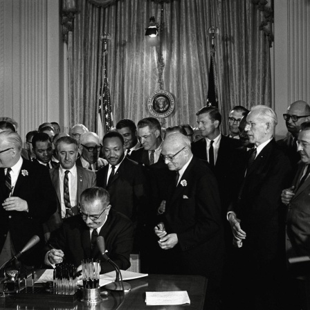 US-Präsident Lyndon Baines Johnson unterzeichnet das Bürgerrechtsgesetz (Civil Rights Act) von 1964, hinter dem Präsidenten steht Bürgerrechtler Martin Luther King