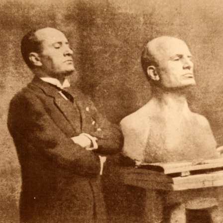 Benito Mussolini neben seiner Büste