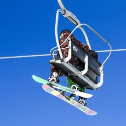 Zwei Snowboarder im Sessellift.