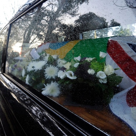 Leichenwagen mit dem Sarg von Ronnie Biggs, eingehüllt in die britische und die brasilianische Flagge und einer Brass Band, die ihm zu Ehren spielt.