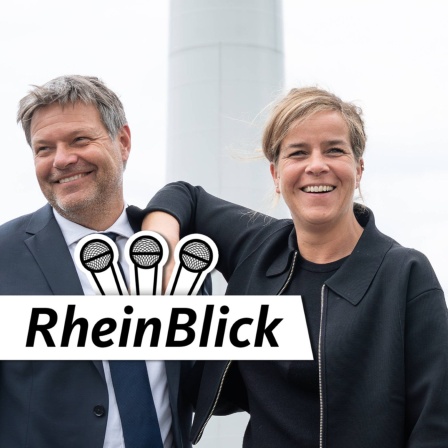 Bundeswirtschaftsminister Robert Habeck (Grüne) und NRW-Wirtschaftministerin Mona Neubaur (Grüne) posieren lachend zusammen vor Windrädern