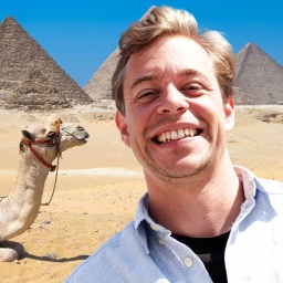 Im Vordergrund Tobi und hinter ihm ein Kamel und eine Pyramide | Bild: Megaherz