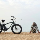 ein Mann mit Fahrrad sitzt am Strand