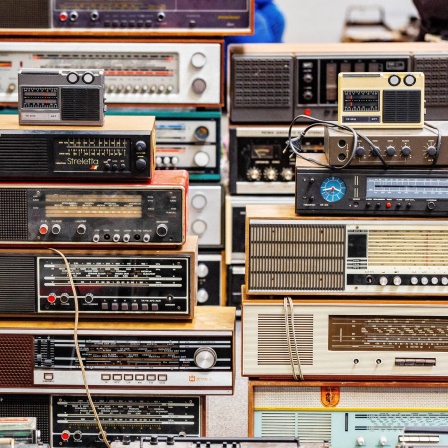 Eine Sammlung aufeinander gestapelter Radios verschiedener Jahrzehnte.