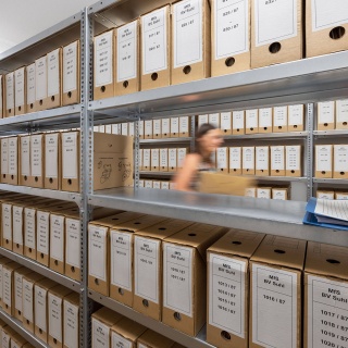 Eine Mitarbeiterin geht durch das Archiv der Stasi-Unterlagen-Behörde © imago images/ari