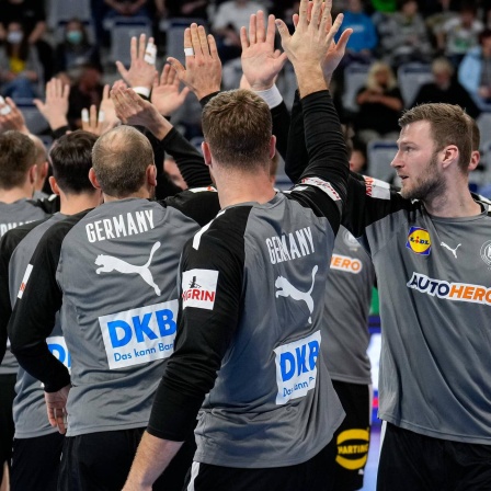 Deutschlands Handballer klatschen vor dem Spiel ab.