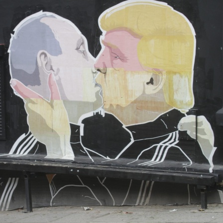 Auf einem Wandgemälde im litauischen Vilnius sind Wladimir Putin und Donald Trump als sich küssendes Paar in Trainingsjacken dargestellt.
