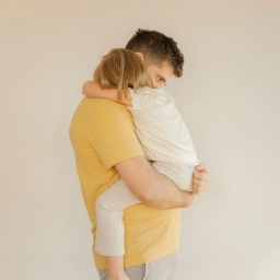 Ein Vater hält seine Tochter tröstend auf dem Arm.
