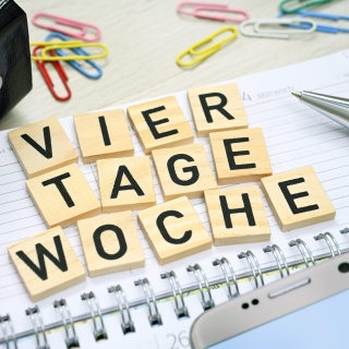 Kalender und Schriftzug Vier-Tage-Woche.

