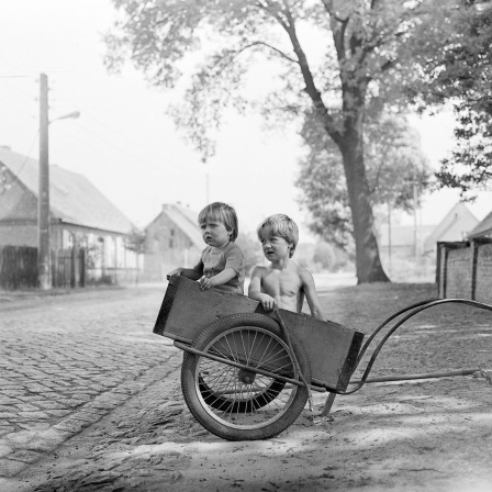 Das Beitragsbild WDR3 "Unverstellte Blicke - Freie Fotografie in der DDR" zeigt ein schwarzweiß Foto von Barbara Wolff "Kinder im Anhänger"