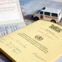 Impfausweis, Pass und Krankenwagen auf einer Landkarte.
