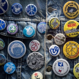 Buttons der Friedensbewegung aus den 1980er Jahren sind in einer Vitrine des Hauses der Geschichte an eine Jeansjacke geheftet; © dpa/Federico Gambarini