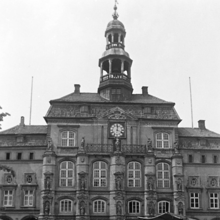 Rathaus Lüneburg 1953: Am 8. Mai 1945 traten hier der Stadtkommandant in Lüneburg und weitere britische Offiziere, die eingesetzten Bürgermeister, Landräte und Amtsträger auf den Balkon und verkündeten der Bevölkerung die bedingungslose Kapitulation der deutschen Wehrmacht