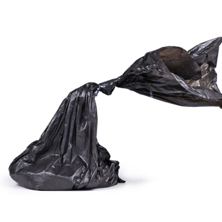 Ein zugeknoteter schwarzer Plastik-Hundekot-Beutel 
