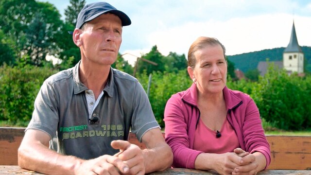 Ulla und Günther Böhringer, Obstbauern, sitzen an einem Holztisch im Freien