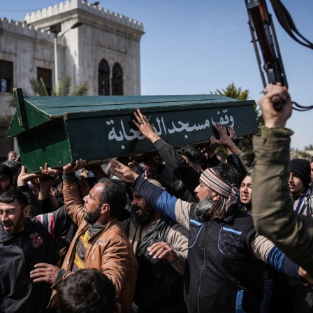 Syrische Kämpfer und Zivilisten tragen den Sarg eines Mitglieds der syrischen Sicherheitskräfte während seiner Beerdigung.