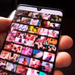 Pornografische Bilder sind unscharf auf dem Bildschirm eines Smartphones zu sehen (Symbolbild)