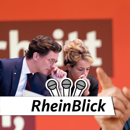 Hendrik Wüst (CDU) und Mona Neubauer (Grüne) tuscheln im Vordergrund, während Jochen Ott (SPD) auf sie zeigt