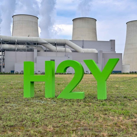 Symbolbild: chemische Element H2 (Wasserstoff) und Buchstabe Y für Hydrogen stehen vom den dampfenden Kühltürmen vom Braunkohlekraftwerk Jänschwalde der Lausitz Energie Kraftwerke AG (LEAG) (Bild: picture alliance/dpa/Patrick Pleul)