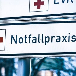 Hinweisschild mit einem roten Kreuz und dem Schriftzug Notfallpraxis