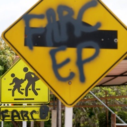 Straßenschild, auf das FARC gesprayt ist