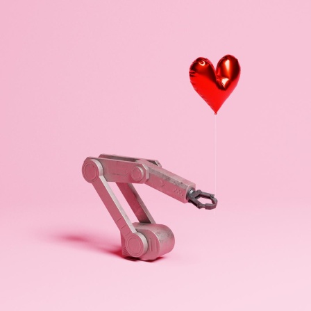Eine Roboterarm, der einen herzförmigen Heliumballon auf einem rosa Hintergrund hält.