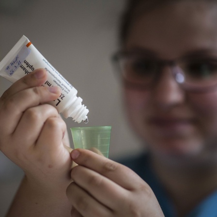 Eine Pflegekraft in einem Pflegeheim misst ein Medikament fuer eine Patientin ab, aufgenommen in Berlin