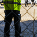 Ein Mitarbeiter einer Sicherheitsfirma bewacht eine Flüchtlingsunterkunft © imago images/Lars Berg