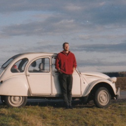 Ein junger Mann steht vor einem Citroen 2CV6 bei Deining, südlich von München.