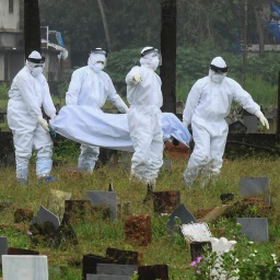 Personen in Schutzkleidung beerdigen auf dem Friedhof ein totes Kind, das an dem Nipah-Virus im indischen Kozhikode gestorben ist. 