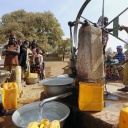 Frauen und Kinder pumpen Wasser an einem Wasserbrunnen Symbolfoto