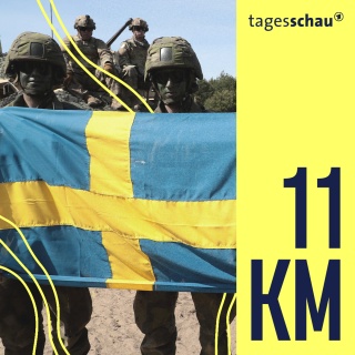 Schwedische Soldaten posieren auf dem Truppenübungsplatz mit einer schwedischen Flagge. 