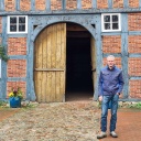 Ein Mann steht vor einem alten Fachwerkhaus