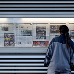 Ein Leser studiert die Schlagzeilen am Aushangkasten der Kölnischen Rundschau. (Themenbild, Symbolbild) Köln, 02.12.2024