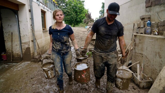 Reporterin Elisa Luzius hilft im Flutkatastrophengebiet in Rheinland-Pfalz einem jungen Mann bei den Aufräumarbeiten