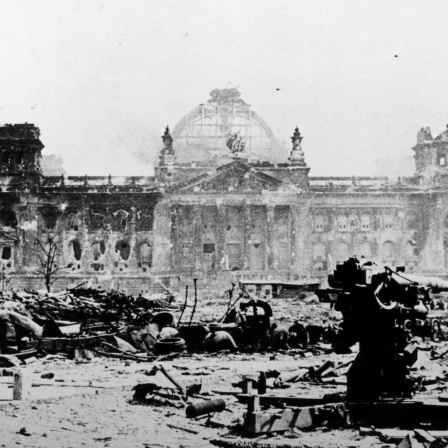 Ein verblichenes schwarz-weiß Foto des zerstörten Reichtagsgebäudes in Berlin im Mai 1945.