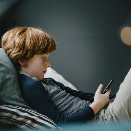 Ein Junge liest auf einem Smartphone