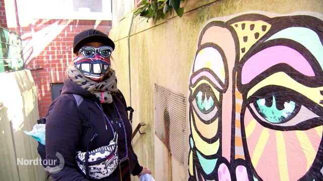 Eine Street Art Künstlerin vor ihrer Kunst.