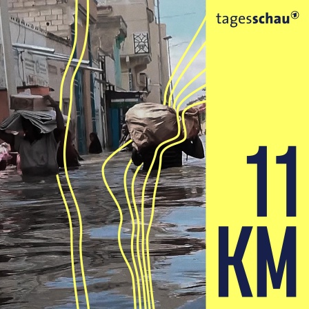 Männer gehen durch das Hochwasser auf der Straße in der somalischen Stadt Beledweyne.
