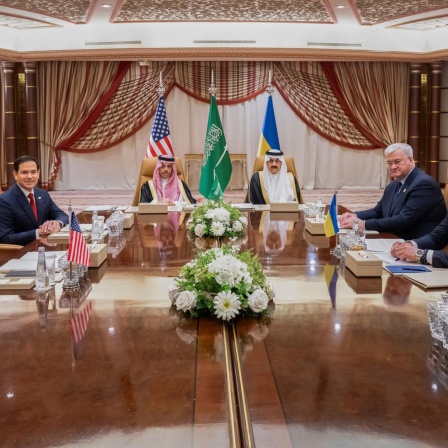 Im Dschidda sitzen Mike Waltz und  Marco Rubio (USA), der saudi-arabische Außenminister Prinz Faisal bin Farhan und Sicherheitsberater Mosaad bin Mohammad al-Aiban sowie der ukrainische Außenminister Andrii Sybiha und Andriy Yermak an einem Tisch.