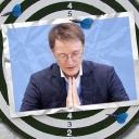 Eine Bildmontage zeigt eine Dartscheibe. Darauf ist eine Postkarte zu sehen, die Bundesgesundheitsminiter Karl Lauterbach von der SPD mit gesenktem Kopf und wie zum Gebet zusammengelegten Händen zeigt.