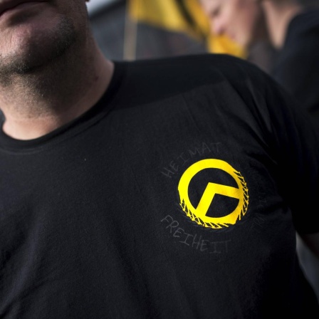 Ein Demonstrant mit dem gelben Logo der Identitären Bewegung auf einem schwarzen T-Shirt bei einer Demonstration der rechtsextremen Jugendbewegung.