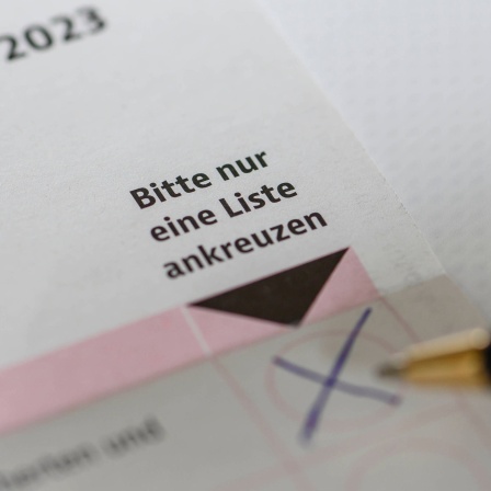 Kreuz auf Stimmzettel zur Sozialwahl 2023, daneben ein Kugelschreiber.