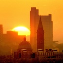 Blick auf die aufgehende Sonne über der Skyline von München